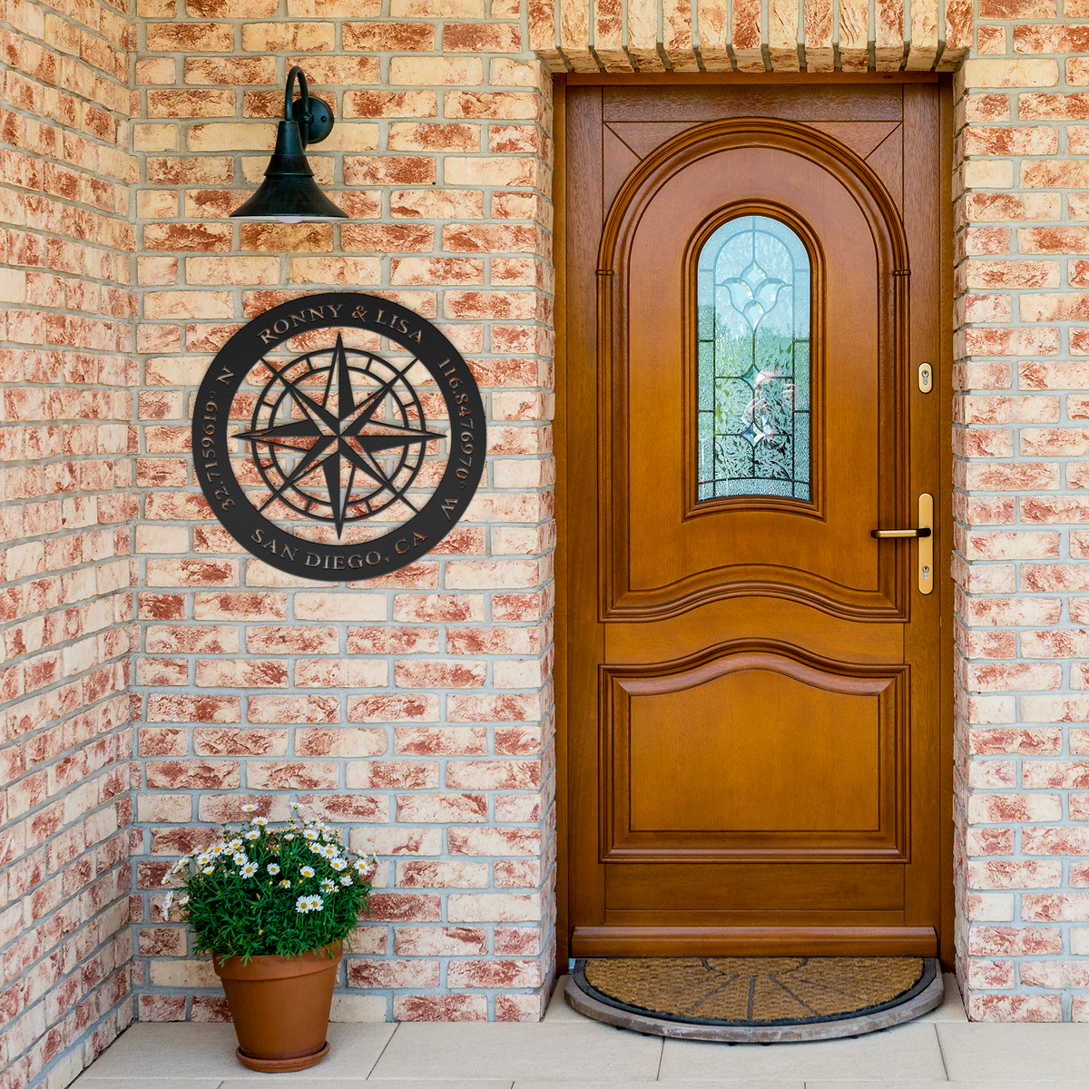 Black custom couples compass coordinates metal sign by brick entrance — personalized couples keepsake wall decor