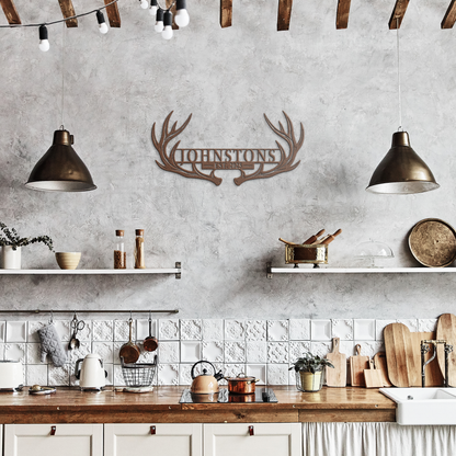 Copper custom deer antler family name metal sign in a rustic kitchen — personalized rustic cabin wall decor