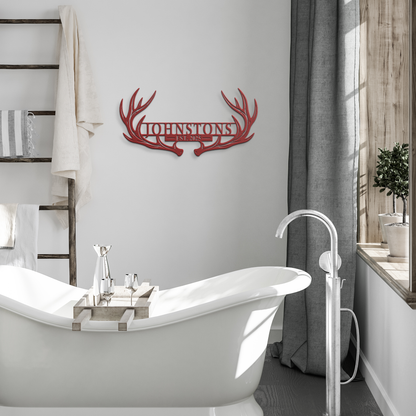 Red custom deer antler family name metal sign in a modern room — personalized rustic cabin wall decor