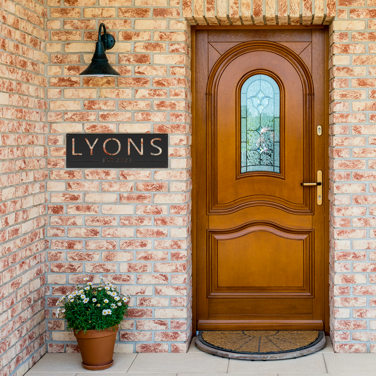 Black custom family name established metal sign by brick entrance — personalized family name decor
