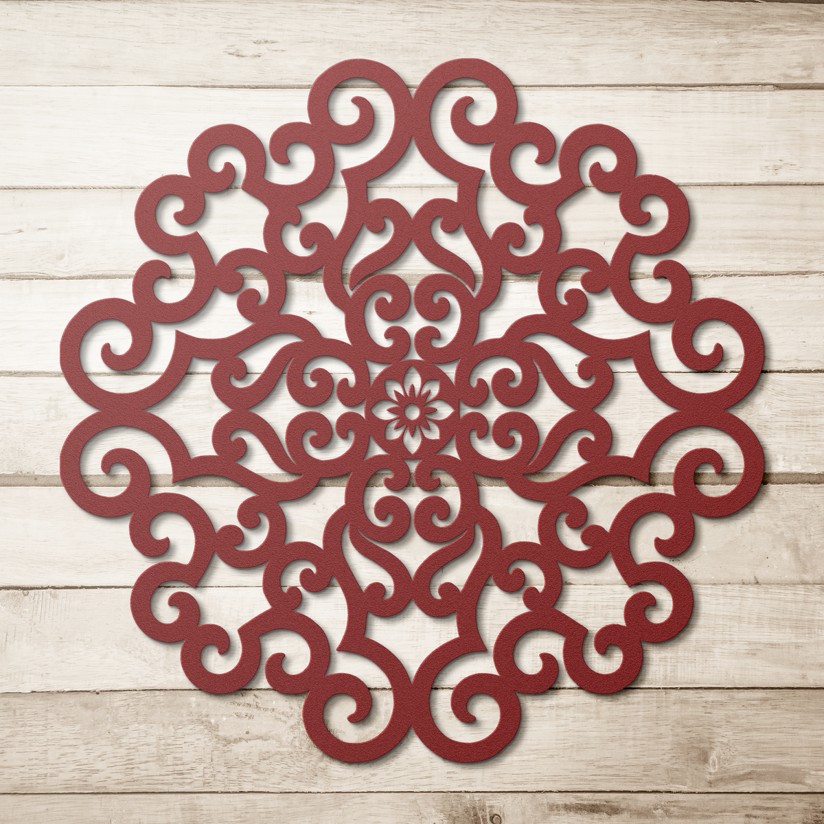 Red ornate scrollwork mandala metal wall art on a wood background — steel wall decor